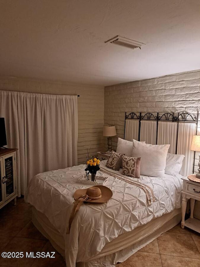 tiled bedroom with brick wall