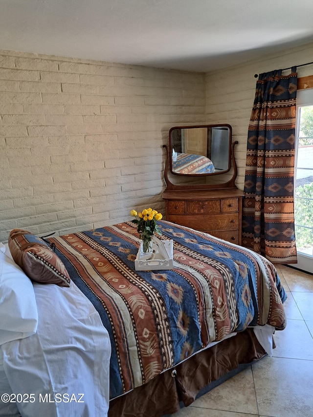 tiled bedroom featuring brick wall