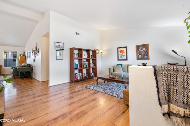 living room featuring lofted ceiling and light hardwood / wood-style flooring