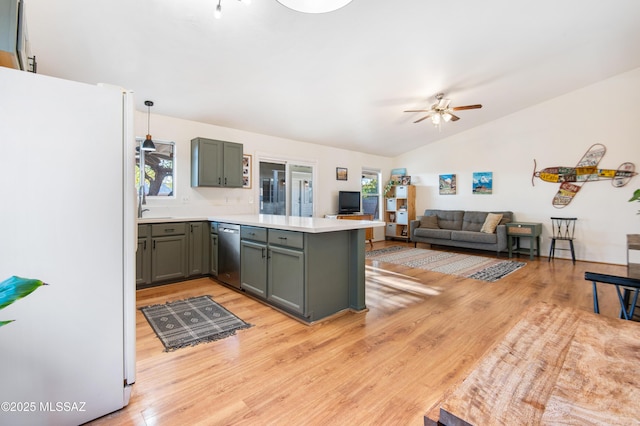 kitchen featuring dishwasher, white refrigerator, decorative light fixtures, vaulted ceiling, and kitchen peninsula