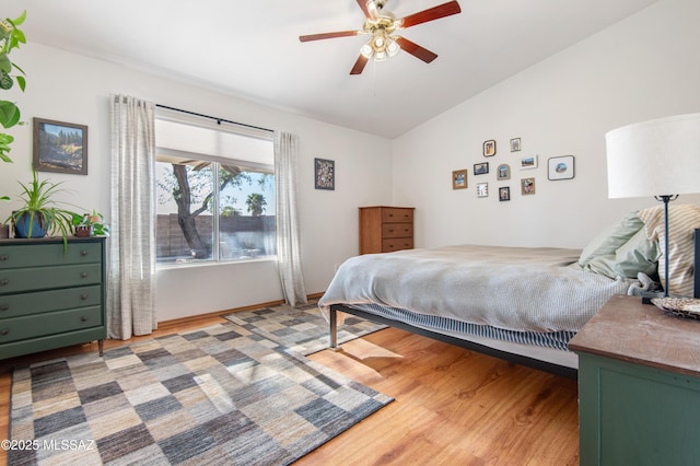 bedroom featuring ceiling fan, lofted ceiling, and wood-type flooring