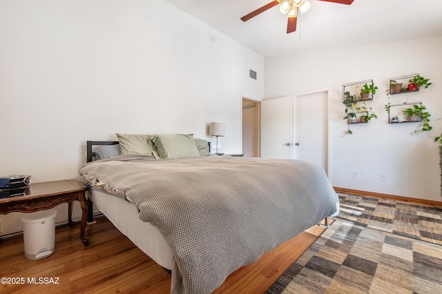 bedroom with ceiling fan, vaulted ceiling, and wood-type flooring