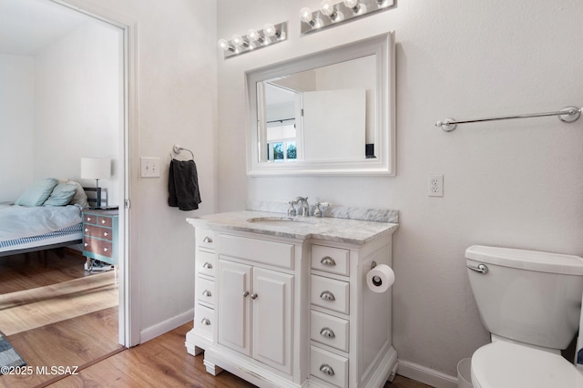 bathroom with hardwood / wood-style flooring, vanity, and toilet