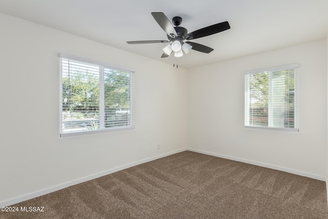 empty room featuring plenty of natural light, carpet floors, and ceiling fan
