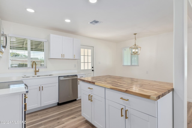 kitchen with pendant lighting, wood counters, white cabinetry, dishwasher, and sink