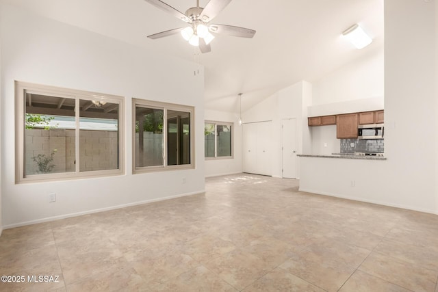 unfurnished living room featuring ceiling fan and high vaulted ceiling