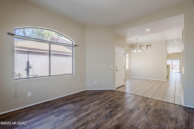 spare room featuring a notable chandelier and wood-type flooring