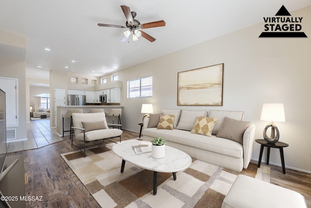 living room with wood-type flooring and ceiling fan