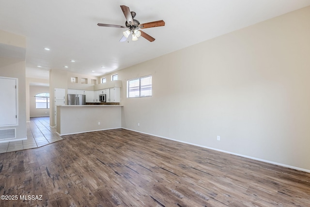 unfurnished living room featuring ceiling fan and light hardwood / wood-style flooring