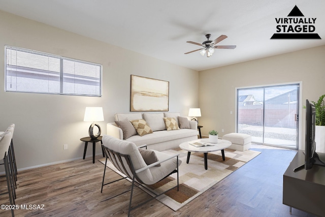 living room featuring wood-type flooring and ceiling fan