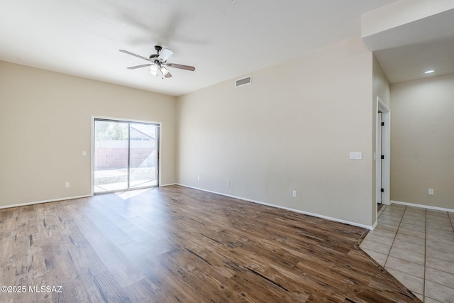 empty room with dark hardwood / wood-style flooring and ceiling fan