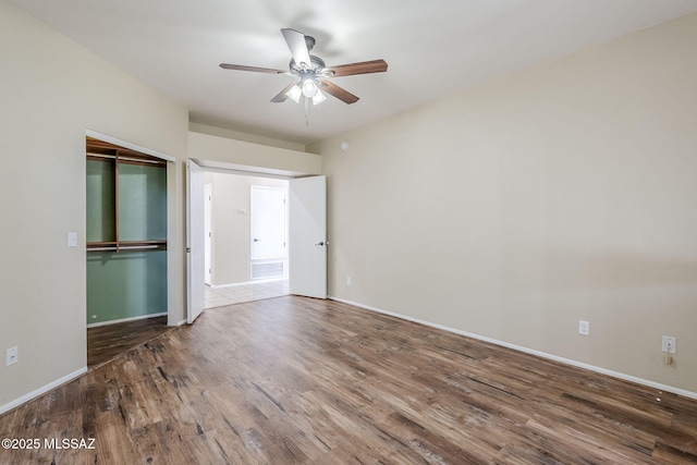 unfurnished bedroom featuring hardwood / wood-style flooring, ceiling fan, and a closet