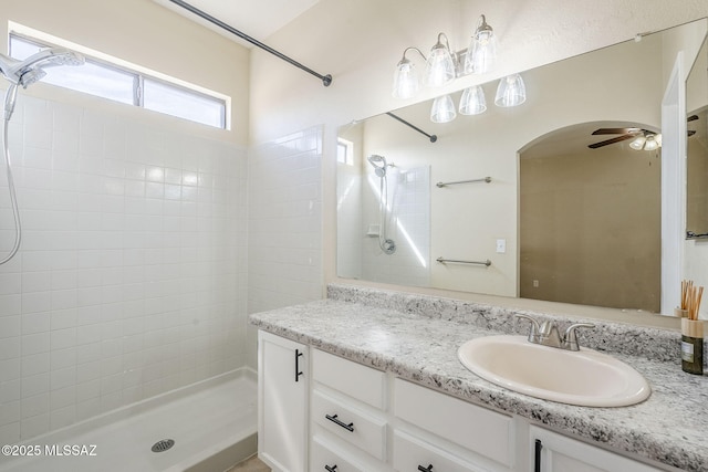 bathroom featuring vanity, ceiling fan, and a tile shower