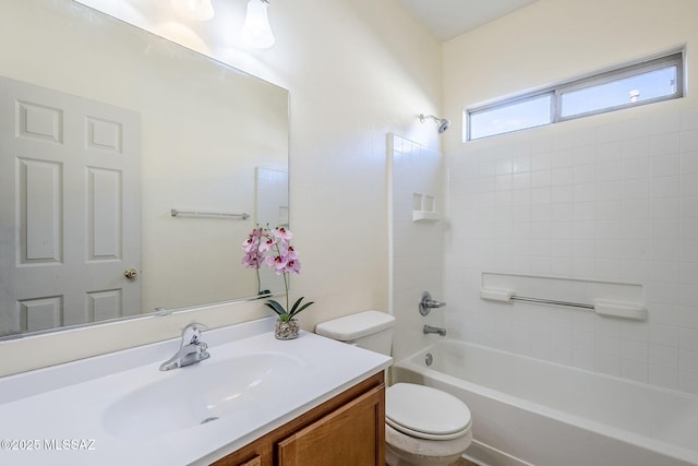 full bathroom featuring tiled shower / bath, vanity, and toilet