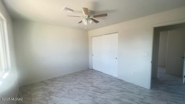 2221 S Sahuara Ave, Tucson, AZ 85711 - unfurnished bedroom with visible vents, a ceiling fan, marble finish floor, and a closet