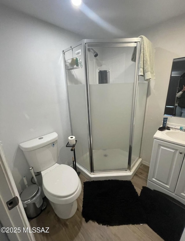2221 S Sahuara Ave, Tucson, AZ 85711 - bathroom featuring wood finished floors, a stall shower, toilet, and vanity
