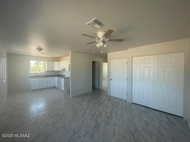 2221 S Sahuara Ave, Tucson, AZ 85711 - unfurnished living room featuring ceiling fan, marble finish floor, and visible vents