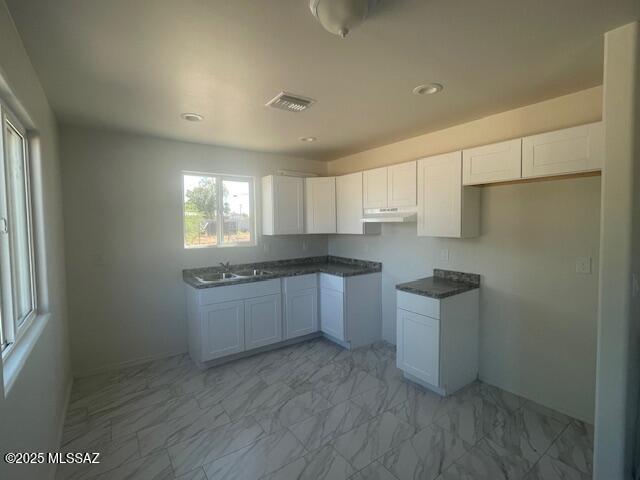 2221 S Sahuara Ave, Tucson, AZ 85711 - kitchen with white cabinetry, visible vents, a sink, and marble finish floor
