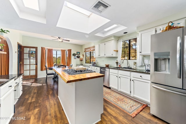 kitchen with white cabinetry, wooden counters, and appliances with stainless steel finishes