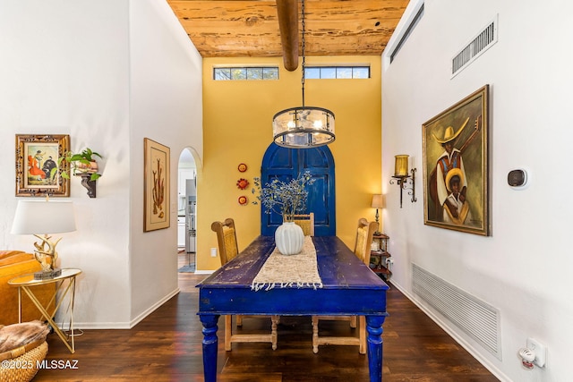 dining room with wood ceiling, dark wood-type flooring, an inviting chandelier, beam ceiling, and a towering ceiling