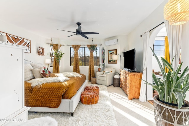 carpeted bedroom with ceiling fan and an AC wall unit