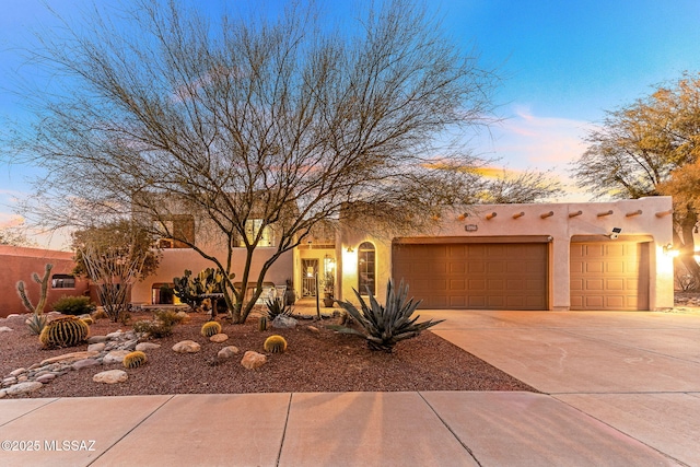 pueblo revival-style home with a garage