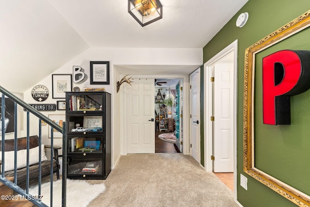 hall with lofted ceiling and carpet flooring