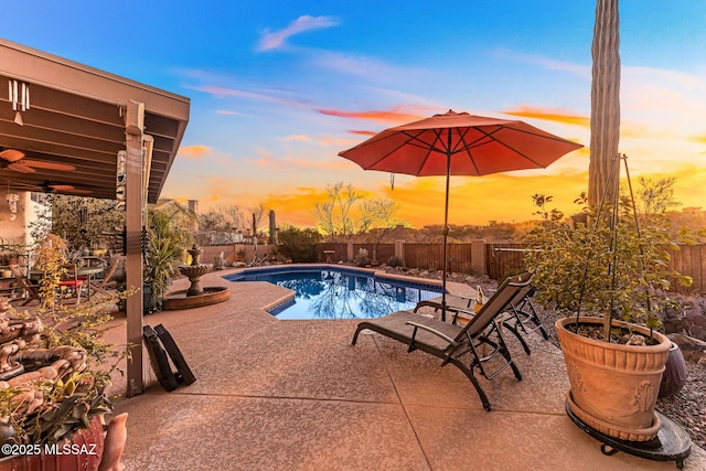 pool at dusk featuring a patio