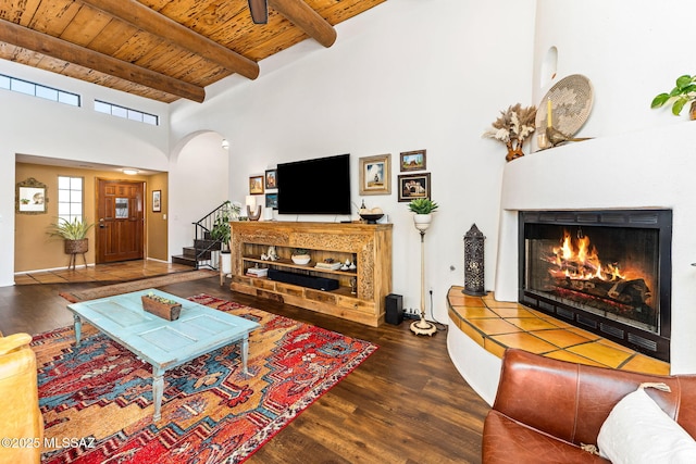 living room featuring beamed ceiling, dark hardwood / wood-style floors, wood ceiling, and a towering ceiling