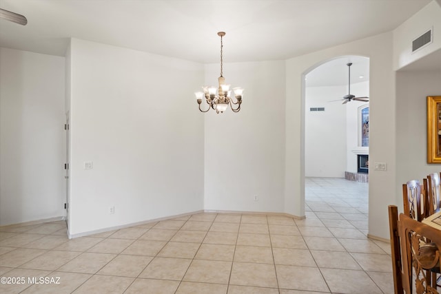 unfurnished room featuring ceiling fan with notable chandelier and light tile patterned floors