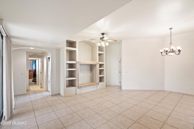 unfurnished living room with ceiling fan with notable chandelier, light tile patterned floors, and built in shelves