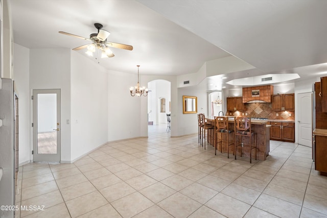 dining area featuring ceiling fan with notable chandelier and light tile patterned floors