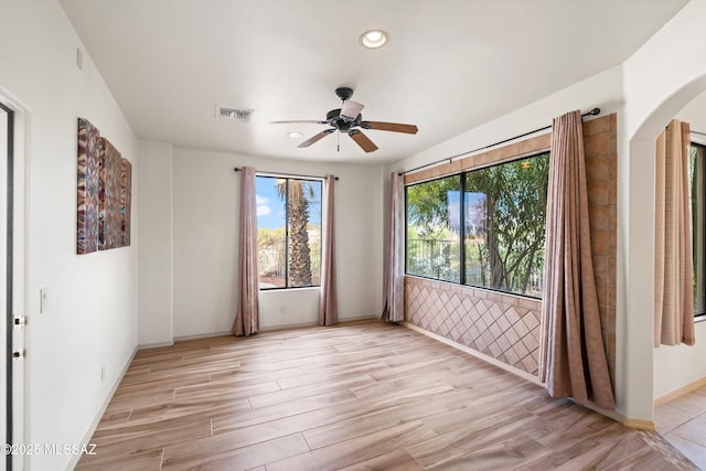 empty room with ceiling fan and light wood-type flooring