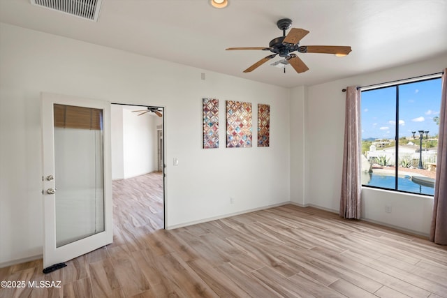 spare room with ceiling fan and light wood-type flooring