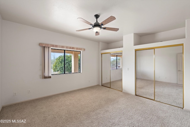 unfurnished bedroom with multiple closets, carpet floors, and ceiling fan