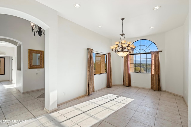 tiled empty room with a chandelier