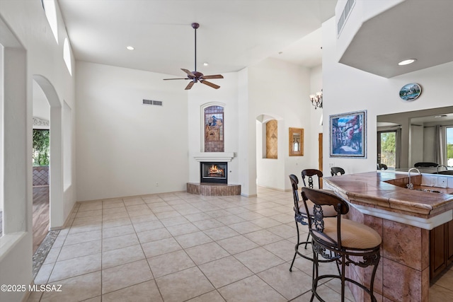 interior space with ceiling fan, sink, and a high ceiling