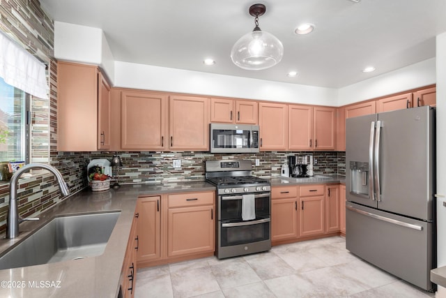 kitchen with pendant lighting, dark countertops, decorative backsplash, appliances with stainless steel finishes, and a sink