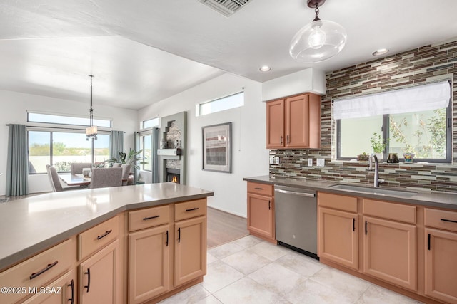 kitchen featuring a sink, visible vents, a lit fireplace, hanging light fixtures, and stainless steel dishwasher