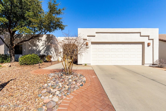 view of front facade with driveway, an attached garage, and stucco siding