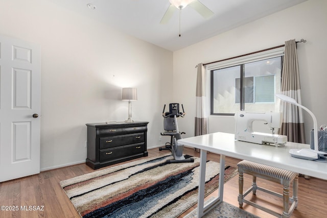 office area featuring baseboards, a ceiling fan, and light wood-style floors