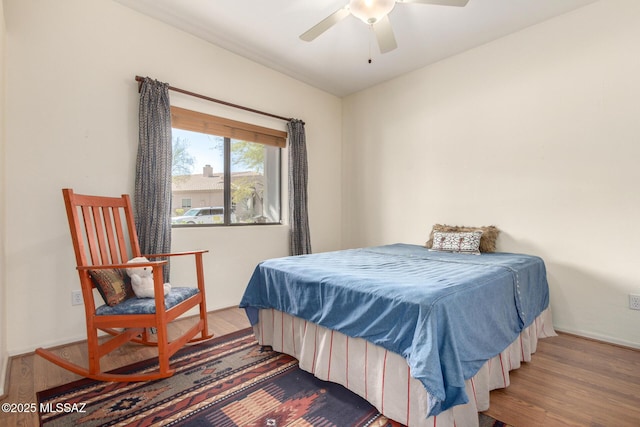 bedroom with a ceiling fan, baseboards, and wood finished floors