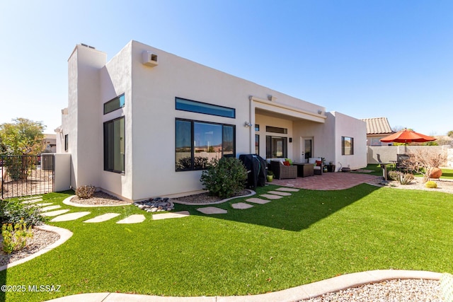 rear view of property featuring a patio area, fence, and stucco siding