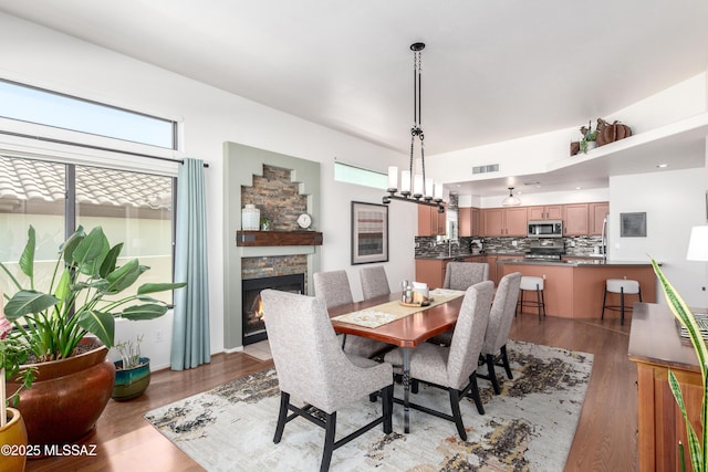 dining area featuring visible vents, a fireplace, and light wood finished floors