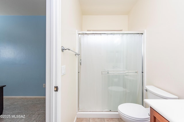 bathroom featuring vanity, toilet, tile patterned floors, and walk in shower