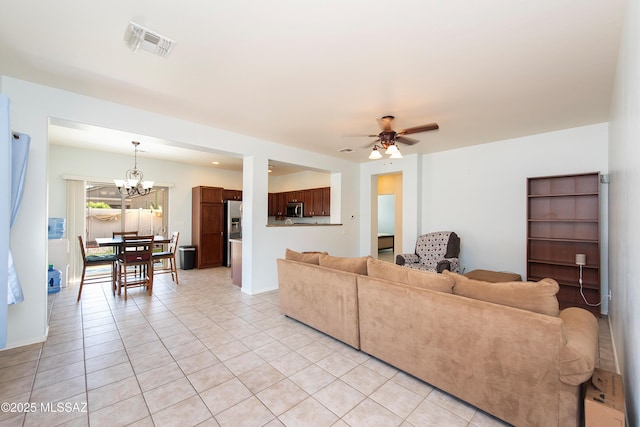 living room with ceiling fan with notable chandelier and light tile patterned floors