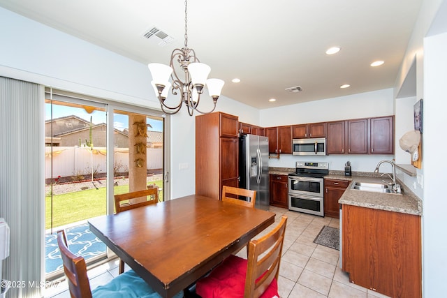 dining space featuring sink, a notable chandelier, and light tile patterned floors