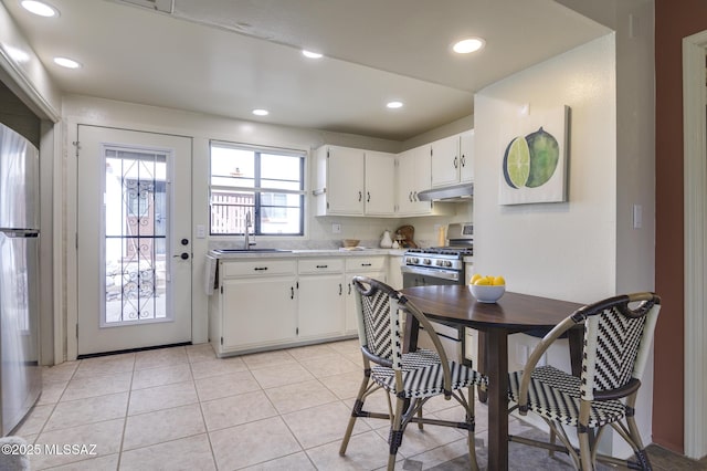 328 S Paseo Pena Unit C, Green Valley, AZ 85614 - kitchen featuring gas stove, a sink, white cabinetry, under cabinet range hood, and light tile patterned floors