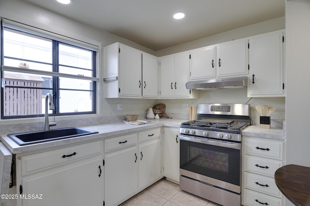 328 S Paseo Pena Unit C, Green Valley, AZ 85614 - kitchen with light tile patterned flooring, white cabinets, stainless steel range with gas stovetop, under cabinet range hood, and a sink