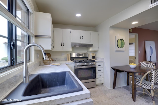 328 S Paseo Pena Unit C, Green Valley, AZ 85614 - kitchen with white cabinetry, light countertops, stainless steel range with gas stovetop, under cabinet range hood, and a sink